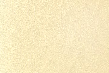 The surface of artificial yellow leather used for furniture upholstery. Uniform light texture.