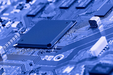 Electronic circuit board with electronic components such as chips close up. Blurry background.	