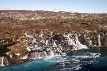Der Wasserfall Hraunfossar des Flusses Hvita nahe Reykolt. / The waterfall Hraunfossar of the river Hvita near Reykolt.