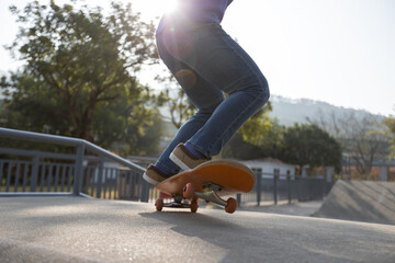 Asian woman skateboarder skateboarding at skatepark