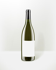 White wine in a green glass bottle with blank paper sticker. Mockup for design