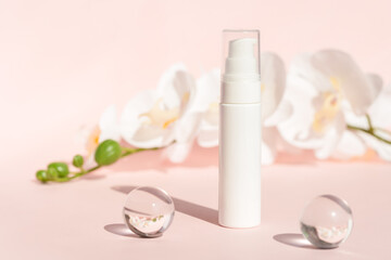Fototapeta na wymiar Cosmetics packaging, product branding, lotion, mask, cleanser container, cosmetic container on pastel background with flowers. Plastic cream bottle mockup on pink pedestal podium. Skin care beauty.