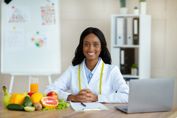 Portrait of professional black dietitian smiling at camera in weight loss clinic. Smart eating...