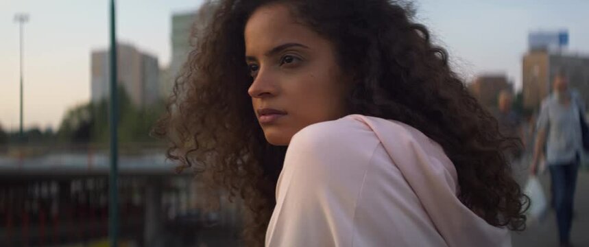 Handheld video of serious beautiful Brazilian woman outside. Shot with RED helium camera in 8K.