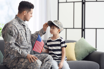 Soldier and his little son with USA flag at home. Memorial Day celebration