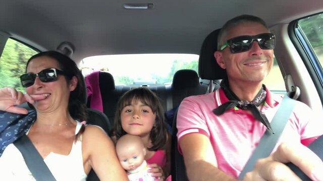 Family singing while driving. Happy father, mother and daughter in a car