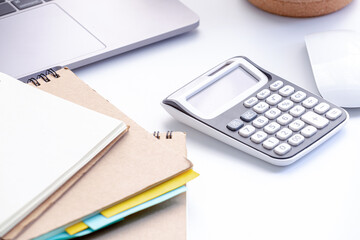 Calculators with a notebook and laptop and a mouse in workspace