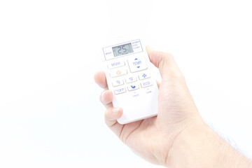 Hand holding the white air conditioner remote control isolated on white background