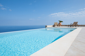 Luxury house with infinity pool over the ocean. - obrazy, fototapety, plakaty