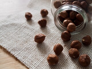 Hazelnuts in a glass jar on wooden background. Copy space