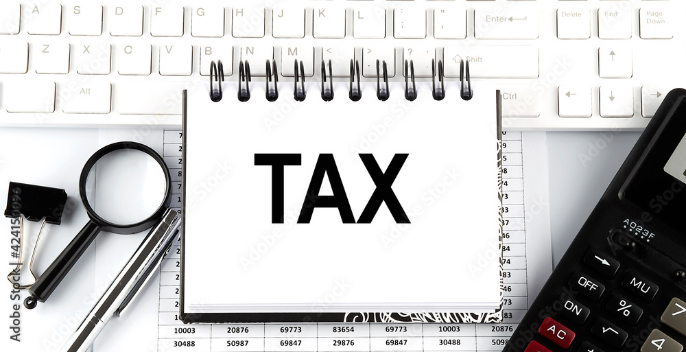 Poster white notebook with text tax on the white keyboard with calculator,magnifier and pen