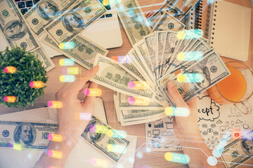 Multi exposure of technology drawing hologram and us dollars bills and man hands. Data concept