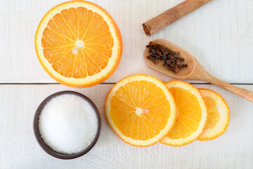 Ingredients for making an orange dessert or jam on a white wooden table. 