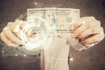 Double exposure of technology drawing hologram and us dollars bills and man hands. Data concept
