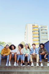 Portrait of young group of friends sitting on the stairs
