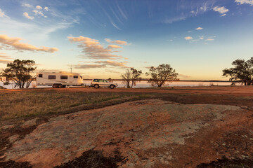 Landscape view of a a large white caravan and modern 4WD vehicle at a free camp next to the nearly dry salt Lake Norring near Wagin in Western Australia in late afternoon sunshine. © Philip Schubert