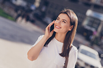 Photo portrait of female student talking on cellphone smiling walking on city streets traveling on holidays