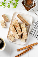 Waffles with chocolate and coffee filling in a white plate on a light background. Lots of wafers on the kitchen table