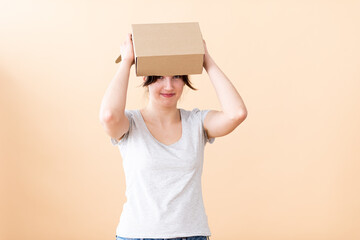 A pretty girl jokingly put a box on her head.