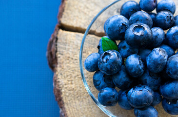 Macro Blueberries in a bowl on a wooden table.