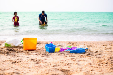 Toy tractor on sand beach at coast with child playing on sea blured. . tourist in vacation travel summer holidays. happy family concept.