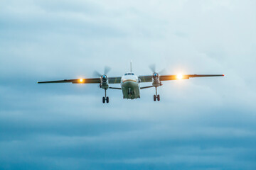 A twin engine airliner is landing at sunset