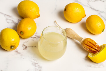 Vaso con zumo de limón natural recien exprimido sobre un fondo de mármol. Vista superior