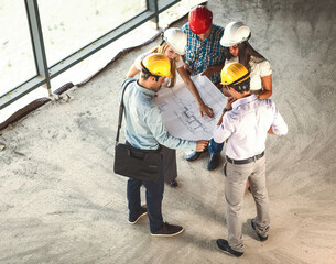 Group of architects and engineers discuss about construction blueprint.High angle view.	
