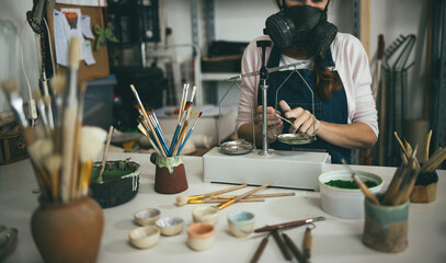 Caucasian woman mixing painting colors with a vintage balance inside her creative pottery studio - Soft focus on hands