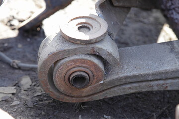 Old rusty heavy truck few-leaf spring with silentblock closeup, commercial vehicle suspension repair service