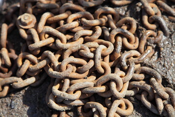 Old rusty chain with welded links on the dirt ground - texture for background, boating, yachting