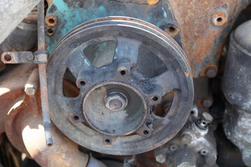 Hydraulic pump pulley wheel without belt on old truck diesel motor engine close up