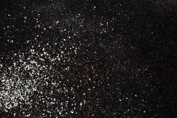 Silver glitter texture on a black background. Holiday background