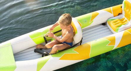 Boy paddling in kayak on mediterranean sea canoe tour, having fun, outdoor activities with children...