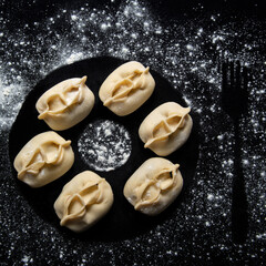 manti semi-finished products on the background of meat in the dough