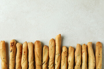 Tasty grissini breadsticks on white textured background