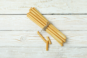 Tasty grissini breadsticks on white wooden background