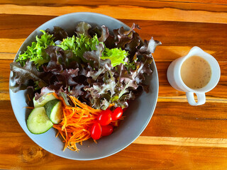 Top view Vegetable Fresh Salad Food Healthy Kitchen Vegetarian Diet Sesame Dressing. Closeup Pour Sesame Dressing on Fresh Salad. Close up Healthy Lunch, Vegetables, cucumbers, carrots, tomatoes.
