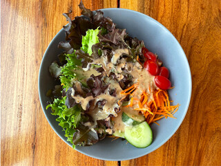 Top view Vegetable Fresh Salad Food Healthy Kitchen Vegetarian Diet Sesame Dressing. Closeup Pour Sesame Dressing on Fresh Salad. Close up Healthy Lunch, Vegetables, cucumbers, carrots, tomatoes.