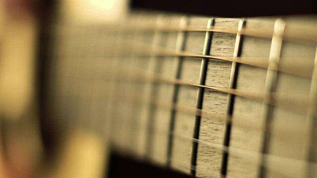 Closeup of guitar neck. Playing the guitar. Strumming on solid spruce acoustic guitar