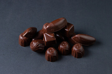 Chocolate bar on a dark background. Chocolate candies on a black background.