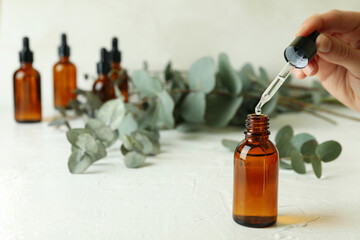 Concept of natural cosmetics with female hand dripping eucalyptus oil