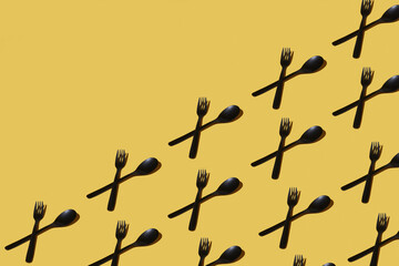 repeated samples of cutlery on a yellow background - 424164241
