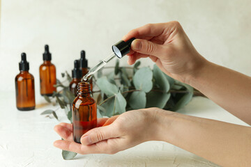 Concept of natural cosmetics with female hand dripping eucalyptus oil