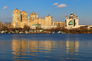 Cityscape view of modern skyscrapers on embankment of the Dnieper River in Kyiv. Concept of modern architecture from steel and concrete. High-rise fashionable houses on the left bank of Dnipro River