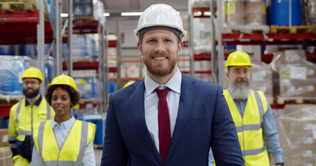 Multiethnic team of warehouse workers smiling at camera