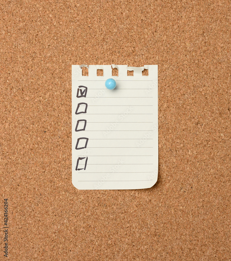 Poster blank sheet of paper in a line attached with a plastic button on a brown cork board