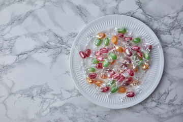colorful candies in plate on a kitchen table - 424166270