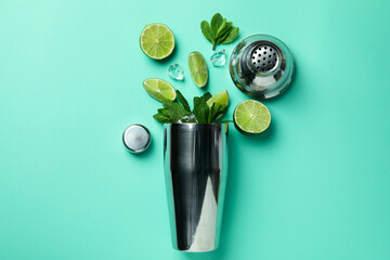 Cocktail shaker and ingredients for mojito on mint background