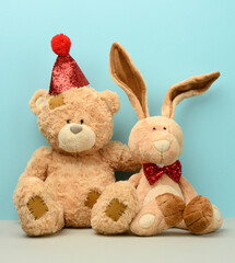 teddy bear in a cap and a cute teddy hare with long ears, a red butterfly is tied around the neck